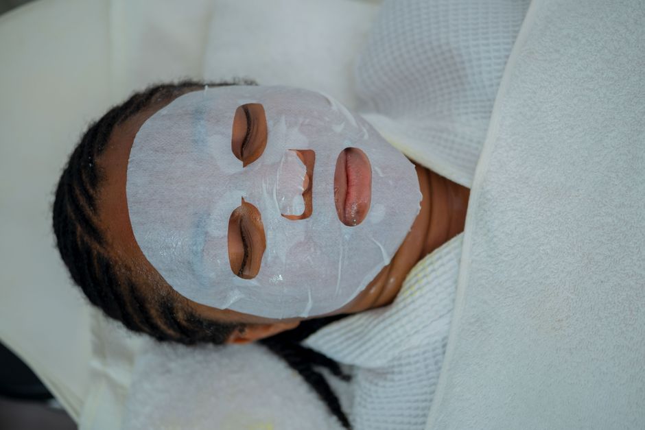Woman enjoying a rejuvenating facial mask treatment at a spa in Abuja, Nigeria.