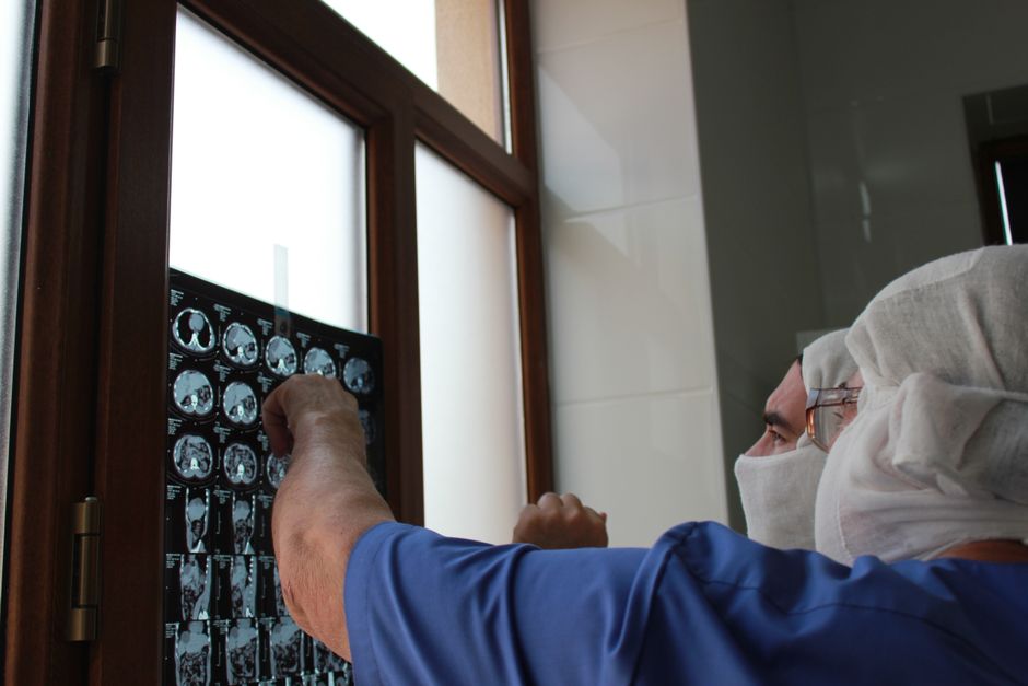 A doctor examines an X-ray film by the window in a medical clinic.