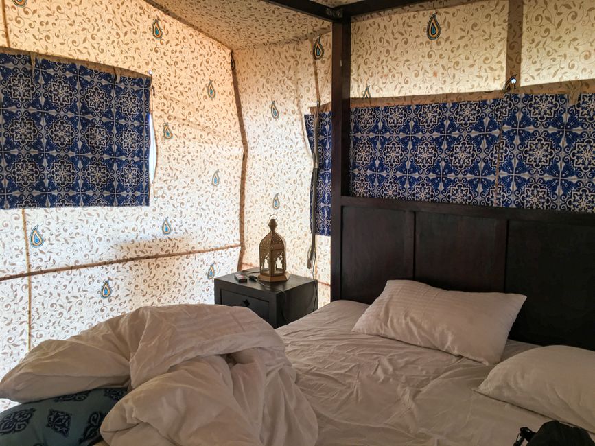 A cozy bedroom with traditional decor and a lantern, located in Diu, India.